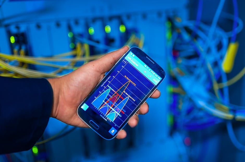 Asmuo su telefonu tikrina Wi‑Fi signalą toje vietoje, kur planuojamas jutiklis
